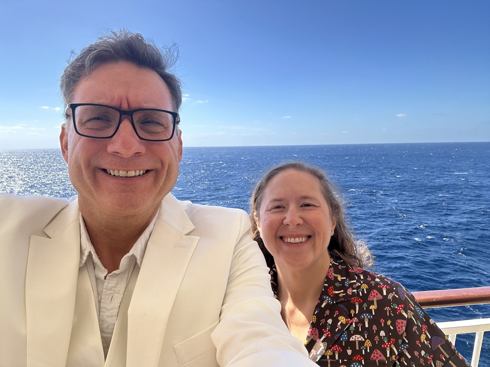 My wife, Amy, and me smiling on a ship with the ocean behind us